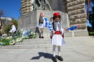Boy in Traditional Greek Uniform Holding a Greek Flag during Independence Day Celebrations